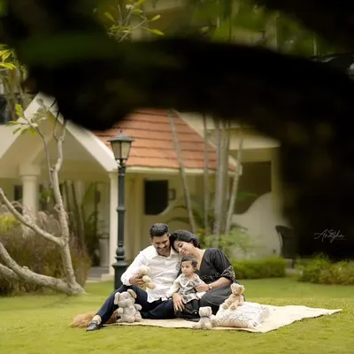 A relaxed family picnic on a beautiful green lawn. This type of outdoor family portrait session is perfect for capturing genuine interactions in a natural setting.