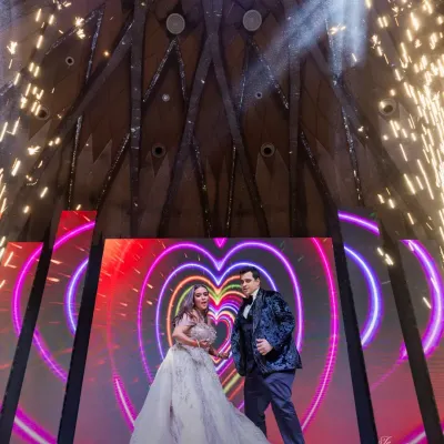 A couple's performance on a grand stage with a heart-themed LED background and dramatic cold pyrotechnics. This is how we create show-stopping moments.