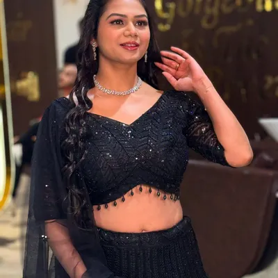 A perfect example of modern party makeup. This look features a flawless HD base, subtly defined eyes, and a natural lip color, allowing her sparkling black lehenga to shine. It's chic, elegant, and perfect for any celebration.