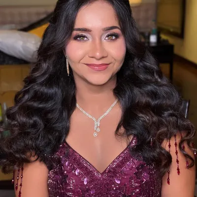 A beautiful reception look featuring soft, voluminous curls. This half-up, half-down style is perfect for showing off long hair while keeping it elegantly styled.