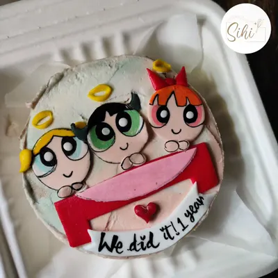 Sugar, spice, and everything nice. This bento cake celebrates a one-year anniversary with the Powerpuff Girls, featuring Blossom, Bubbles, and Buttercup made from colorful fondant.