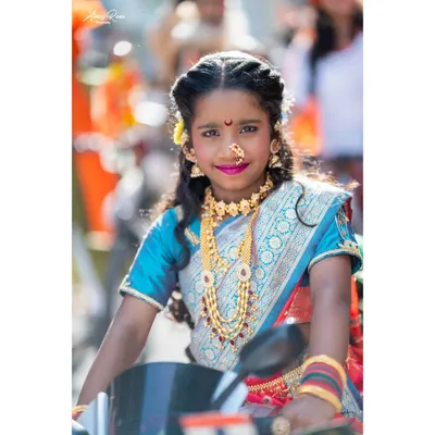 A stunning portrait of a young girl dressed in a traditional Paithani saree for the Gudi Padwa festival. Her confident smile, intricate jewelry, and the festive atmosphere are captured beautifully.