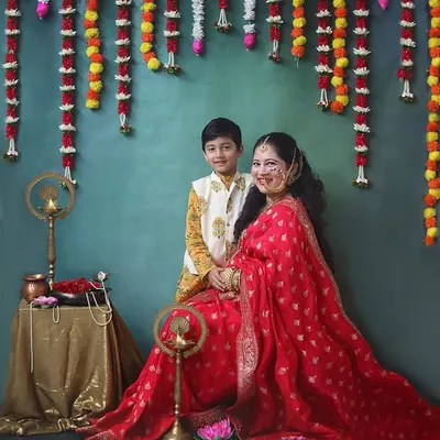 Celebrating tradition and motherhood with this stunning mom to be and her son. The rich red saree and festive backdrop with marigold flowers create such a warm and vibrant maternity portrait.