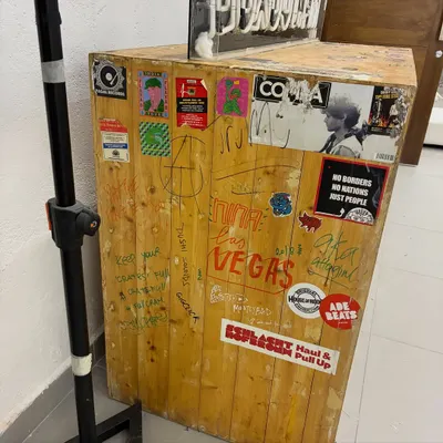 The original, custom-built Boxout.fm DJ booth, covered in stickers and signatures. This piece of furniture holds years of history and represents the community we've built.
