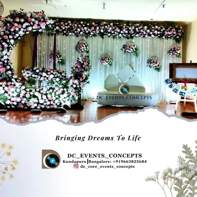 A dreamy cradling ceremony setup featuring a crescent moon floral arch. The soft color palette, hanging flower baskets, and a personalized photo easel create a beautiful and serene atmosphere.