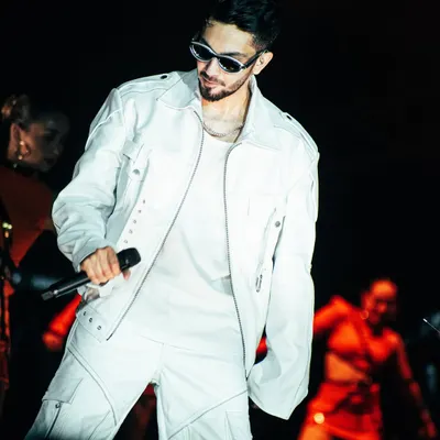 Anirudh Ravichander looking cool and confident in an all-white outfit during his Hukum Tour in Bangalore. This is a classic portrait of a modern music star.