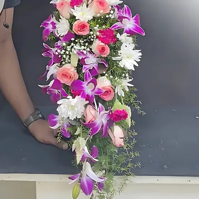 This beautiful cascade-style bouquet features a graceful waterfall of roses, carnations, and orchids. This is a classic and elegant bridal bouquet style that our students master in the advanced modules.