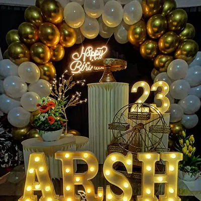 This is what a milestone birthday celebration looks like. We combined a classic gold and white balloon arch with a custom neon sign and personalized light-up letters for "ARSH" to create a stunning photo corner for the 23rd birthday party.