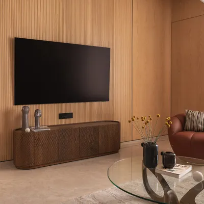 Soft tones and sculptural forms create effortless warmth in this living room. I brought together fluted wood panels, cozy textures, and organic curves to design a space that feels calm, modern, and deeply lived-in.