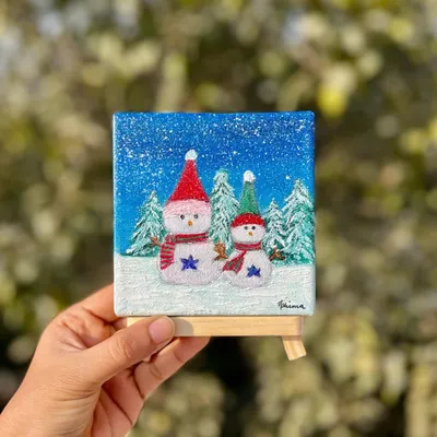 This miniature Christmas painting features two happy snowmen in a winter forest. It’s a small, festive artwork that makes a unique and personal gift or a cute addition to your holiday decorations.