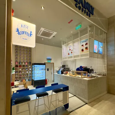 A wide shot of the Beanly cafe, showing how we translated the online brand into a physical space. The design balances the bold electric blue counter with warm wood tones and a clean, white service area, creating a welcoming and energetic atmosphere.