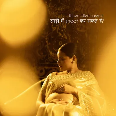 "When client asked, 'साड़ी में shoot कर सकते हैं?'" Our answer is always yes. This image, with its warm golden light and rich tapestry background, shows how beautifully a saree can be incorporated into a maternity shoot, celebrating both culture and motherhood.
