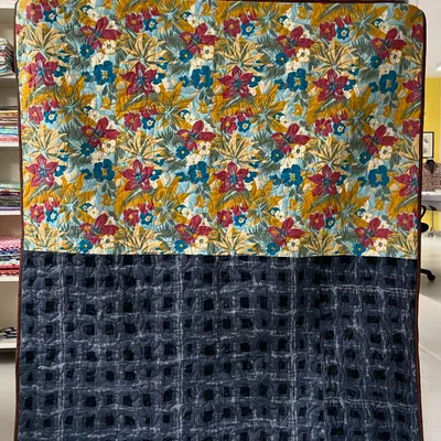 The back of a jelly roll quilt, featuring a combination of a beautiful floral print and a dark, textured fabric.