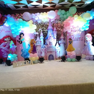 A magical princess party with a castle backdrop and cutouts of famous princesses like Rapunzel, Belle, and Jasmine. The pastel balloon decor adds to the enchanting atmosphere.
