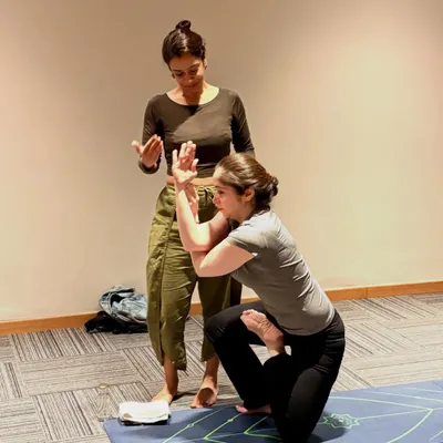 I love each of my students. When I teach, I give every ounce of my energy to their growth. Here, I am assisting a student in Vatayanasana, helping her find the correct alignment in the arms.