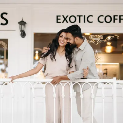 A candid moment of laughter on the balcony of a chic cafe. This type of shoot is perfect for couples who want a relaxed, modern, and stylish pre-wedding session.