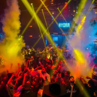 An aerial view of the packed dance floor at Hydra, lit up by yellow laser beams and smoke effects. This is the peak-hour energy I build with my commercial and techno sets.