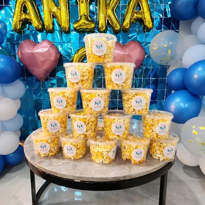A tower of our packaged popcorn tubs, ready for guests at Antika's birthday party. These make for a perfect and easy party favor.