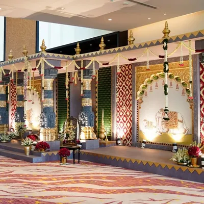 The grand entrance to our temple wedding concept. We designed this passage with towering Tanjore paintings, intricate floral work, and cascading garlands to transport guests into a world of divinity and artistry before they even entered the main hall.