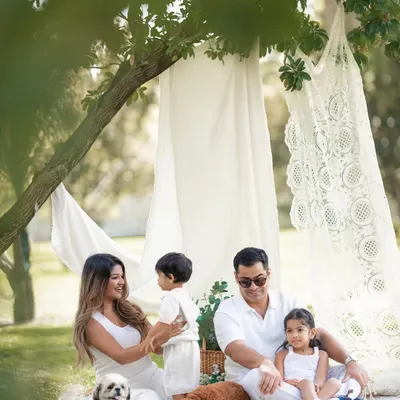 A beautiful family enjoying a picnic under the trees. I love capturing these candid moments of interaction and play during our outdoor sessions.