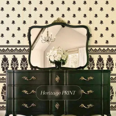 This heritage print wallpaper combines a small, delicate buti pattern with a bold, contrasting border. Paired with ornate, dark furniture, it creates a look that is both classic and dramatic.