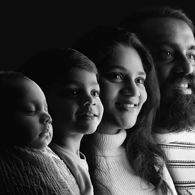 A beautiful and artistic black and white family portrait, showing the profiles of each family member from dad to the newborn. This is a unique way to represent the family growing together.