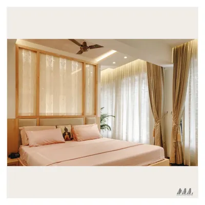 This bedroom is designed for calm and comfort. The space features a custom wooden headboard with translucent panels, soft drapery to filter natural light, and a soothing color scheme.