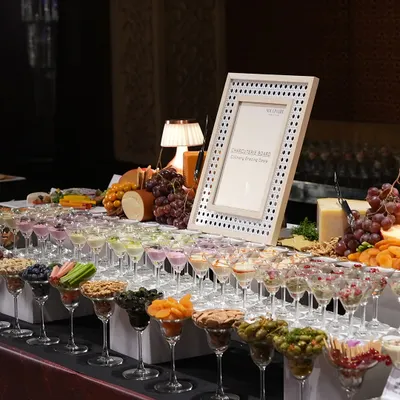 A magnificent charcuterie and cheese board, artfully arranged in martini glasses and on platters. This is a perfect example of how we turn simple grazing into an exquisite experience.