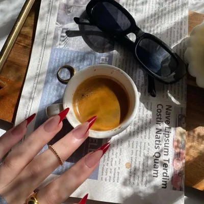 That morning coffee moment, made even better with a set of sharp, red stiletto nails.