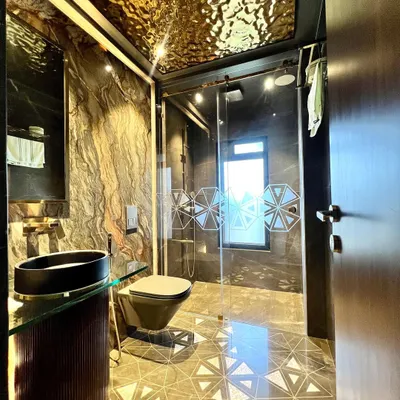 This bathroom is a statement in glamour. We used a liquid metal-effect ceiling, dark marble walls, and mother-of-pearl floor inlays to create a space that is truly magnificent and opulent.