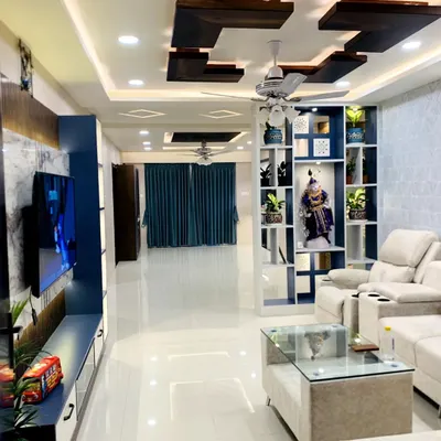 A full view of a spacious living room designed for comfort and style. The layout promotes easy conversation, while the custom TV unit and multi-level false ceiling with distinct lighting add a touch of modern luxury and help balance the room's energy.