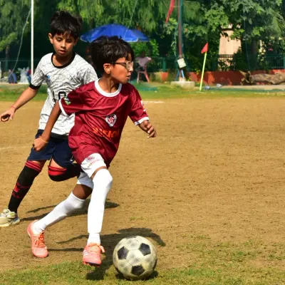 A young player skillfully dribbles past a defender during an RSA tournament match. This is the result of countless hours spent on technical drills, now applied in a competitive environment.