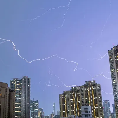 A web of lightning spreads across the purple night sky above the dense architecture of Mumbai.
