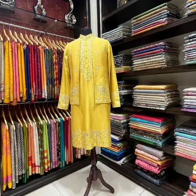 A custom-tailored menswear set in our store. This yellow silk kurta with a matching embroidered jacket is an example of the festive attire we create for our clients.