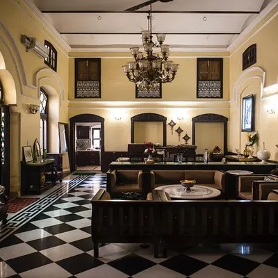 The main hall of a 19th-century haveli in Old Delhi after restoration. We revived the space as a contemporary home, restoring the original checkerboard flooring, intricate door arches, and installing a period-appropriate chandelier to bring back its former grandeur.