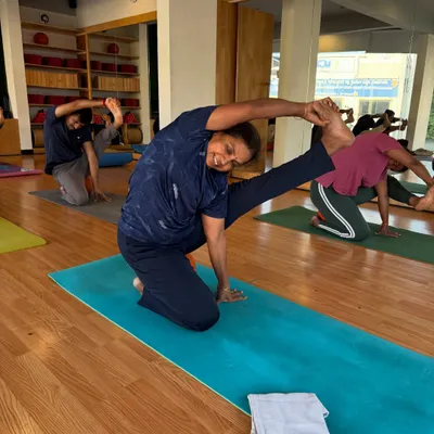 Feel the magic of movement. A student demonstrates a beautiful side stretch, showcasing the flexibility and grace developed through consistent practice.