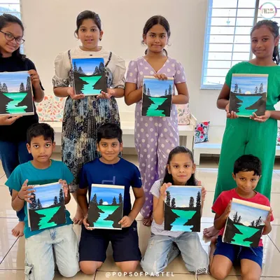 A group of proud young artists showing off the landscape paintings they completed during our 10-day acrylic painting course.