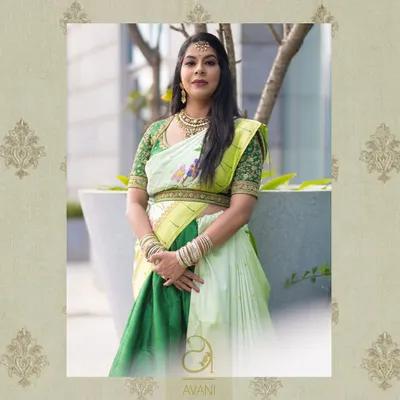 A client wearing a custom green blouse with delicate hand-painted floral details. This image captures the unique artistry that can be incorporated into my bespoke designs.