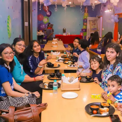 Families enjoying a meal together in our spacious cafe area. The cafe is conveniently located right next to the play zones.