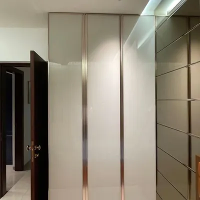 This custom hinged wardrobe features frosted glass panels and elegant rose-gold metallic trim, creating a sophisticated and modern look for your bedroom. We designed it to blend seamlessly with the room's decor while providing a statement of style.