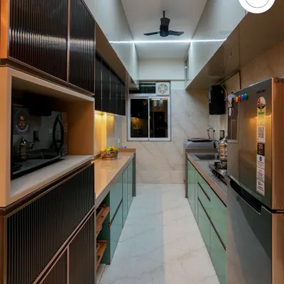 A sleek parallel kitchen design in a striking teal and grey combination. We used fluted glass for the overhead cabinets and integrated lighting to create a high-end, modern look.