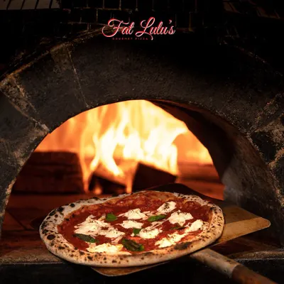 This is the heart of our craft. Our Neapolitan pizza dough is made with '00' flour, rested for up to 36 hours, and then baked in a scorching wood-fired oven to create that signature charred leopard-spot crust.