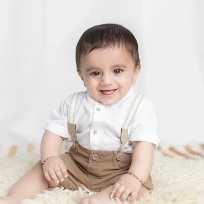 What a happy smile! Sitter sessions around 7-9 months are perfect for capturing your baby's joyful personality as they learn to sit up on their own.