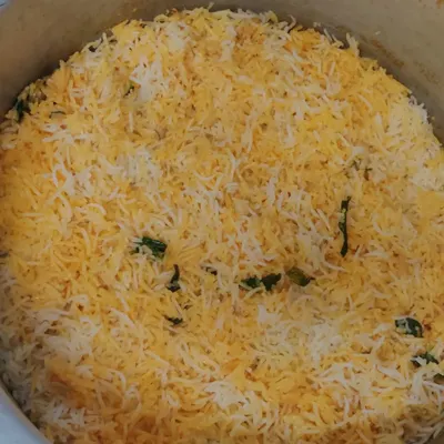 A large pot of our authentic Muslim biryani, cooked over firewood to achieve a distinct flavor. We prepare this in bulk for large corporate lunch orders, ensuring every serving is perfect.