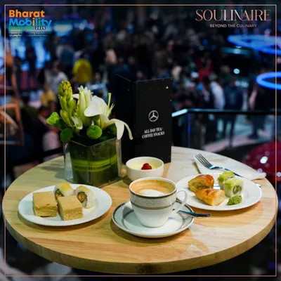 A sophisticated spread of coffee and gourmet snacks at the Mercedes-Benz pavilion during the Bharat Mobility Global Expo. We provide premium hospitality that aligns with the world's leading luxury brands.