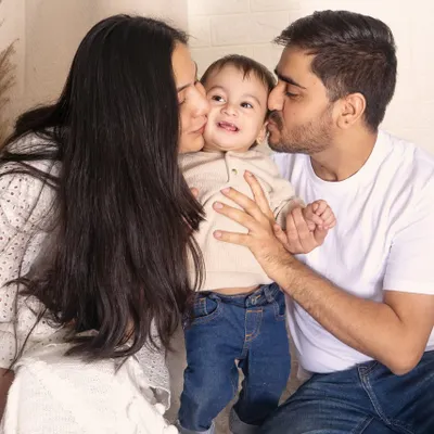 A heartwarming and candid family moment, with both parents giving their little one a kiss on the cheek. These are the precious, unposed memories I love to capture.