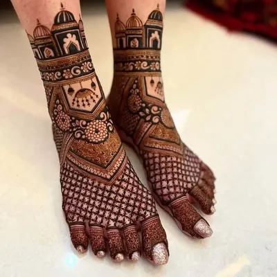 This foot mehandi features bold architectural dome (gumbad) patterns on the ankles. The design combines a dense checkerboard (jaali) pattern on the foot with clean, open toes.