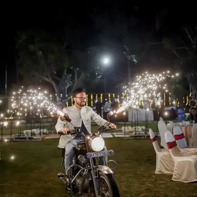 The groom makes his solo entry on a classic Royal Enfield, complete with handlebar-mounted sparklers. This is a total hero moment that gets the crowd hyped up for the night.