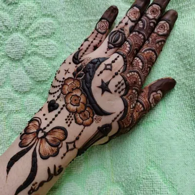 A whimsical and charming design perfect for a party or special event. It features a crescent moon, stars, a bow, and delicate floral elements, with a name personalized on the wrist.