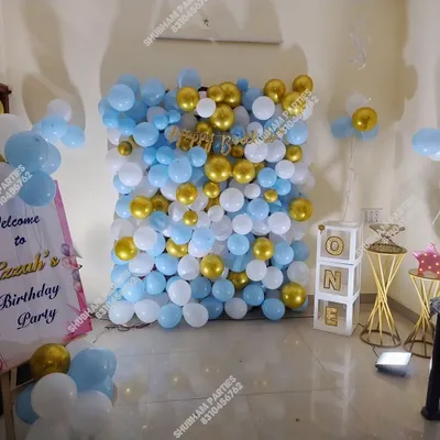 A full balloon wall in light blue, white, and gold, creating a fantastic photo backdrop.